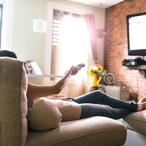 woman sitting on couch watching tv